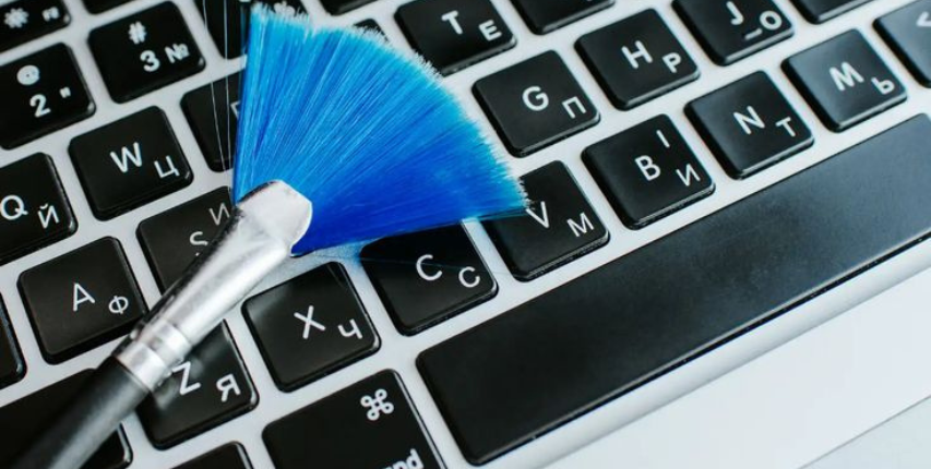Cleaning a laptop keyboard with a brush for maintenance and dust removal